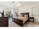 Sunny main bedroom with large bed, ceiling fan, and sliding glass door to backyard at 9256 Blue Flax Pl, Las Vegas, NV 89148