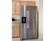 Stainless steel refrigerator with water dispenser and wood cabinets at 9256 Blue Flax Pl, Las Vegas, NV 89148