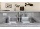 Close-up of a stainless steel kitchen sink with modern faucet fixtures and granite countertops at 9256 Blue Flax Pl, Las Vegas, NV 89148