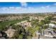 Expansive aerial view of a luxury community featuring lush landscaping, a golf course, and distant city skyline views at 9408 Players Canyon Ct, Las Vegas, NV 89144