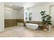 Modern bathroom featuring a luxurious soaking tub and a spacious glass-enclosed shower with marble accents at 9408 Players Canyon Ct, Las Vegas, NV 89144