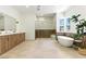 Bright bathroom showcases a double vanity, soaking tub, and glass shower with gold fixtures and modern design at 9408 Players Canyon Ct, Las Vegas, NV 89144