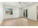 Spacious bedroom with light wood floors, French doors and a view of lush landscaping at 9408 Players Canyon Ct, Las Vegas, NV 89144