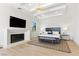 Bright bedroom features a modern fireplace, TV, and a tray ceiling with a striking chandelier at 9408 Players Canyon Ct, Las Vegas, NV 89144