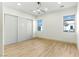 Minimalist bedroom with modern ceiling fan, closet and two windows allowing for plenty of natural light at 9408 Players Canyon Ct, Las Vegas, NV 89144