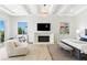 This bedroom is bathed in light from large windows and features a modern fireplace and tray ceiling at 9408 Players Canyon Ct, Las Vegas, NV 89144
