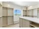 Well-organized walk-in closet with built-in shelves, drawers, seating and a view overlooking the golf course at 9408 Players Canyon Ct, Las Vegas, NV 89144