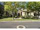 Charming single-story home with mature trees, a well-manicured lawn, and inviting curb appeal at 9408 Players Canyon Ct, Las Vegas, NV 89144
