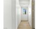 Bright hallway featuring light wood floors and view to a window at 9408 Players Canyon Ct, Las Vegas, NV 89144