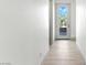 Bright hallway with light wood floors leading to an outdoor patio with a glass door at 9408 Players Canyon Ct, Las Vegas, NV 89144