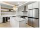 Bright kitchen showcasing white cabinets, stainless steel appliances, island, and open shelving at 9408 Players Canyon Ct, Las Vegas, NV 89144