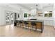 Spacious kitchen featuring a large island with seating, modern lighting, and backyard views at 9408 Players Canyon Ct, Las Vegas, NV 89144