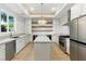 A modern kitchen features an island, stainless steel appliances, and open shelving at 9408 Players Canyon Ct, Las Vegas, NV 89144