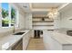 Bright kitchen featuring an island, open shelves, modern lighting, and stainless appliances at 9408 Players Canyon Ct, Las Vegas, NV 89144