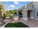 Backyard showcasing an outdoor kitchen and lush landscaping, ideal for entertaining guests at 9408 Players Canyon Ct, Las Vegas, NV 89144