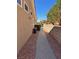Side yard with gravel landscaping, a concrete walkway, and secure fencing at 10036 Keysborough Dr, Las Vegas, NV 89134