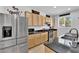 Well-lit kitchen featuring stainless steel appliances, dark countertops, and wooden cabinets at 10045 Natchez Trace St, Las Vegas, NV 89178