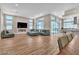 Open-concept living room featuring wood floors, a fireplace, recessed lights, and a large sectional couch at 10301 Fairview Ridge Ct, Las Vegas, NV 89166