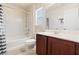 Bright bathroom featuring a shower-tub combo, window, and vanity with dark wood cabinetry at 10478 Beallsville St, Las Vegas, NV 89141