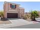 Inviting front exterior showcasing a two-car garage, desert landscaping and an arched entryway at 10478 Beallsville St, Las Vegas, NV 89141