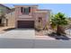 Charming home featuring a well-manicured front yard with a two car garage and desert landscaping at 10478 Beallsville St, Las Vegas, NV 89141