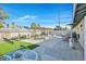 The backyard is set up with a lounging area, dining set, green turf, desert landscaping, and privacy fencing at 105 Shadow Ln, Las Vegas, NV 89106
