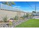 Landscaped backyard featuring desert plants, rocks, and artificial grass creates a low-maintenance and visually appealing outdoor space at 105 Shadow Ln, Las Vegas, NV 89106