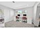 This home office features two desks, carpet flooring, two chairs, a bright window, and minimalist decor at 105 Shadow Ln, Las Vegas, NV 89106