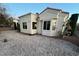 Backyard view, featuring gravel landscaping, window views, and privacy hedges at 10717 Grand Cypress Ave, Las Vegas, NV 89134