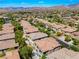 Expansive aerial view of a desert community with meticulously maintained landscaping and mountain views at 11901 Luna Del Mar Ln, Las Vegas, NV 89138