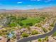 Expansive aerial view of the community with a large recreational park, trees, and desert mountains in the background at 11901 Luna Del Mar Ln, Las Vegas, NV 89138