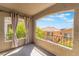 View of the outside neighborhood on a balcony with neutral toned curtains and a metal railing at 11901 Luna Del Mar Ln, Las Vegas, NV 89138