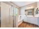The bathroom has dual sinks, a shower with glass doors, a bathtub, and wood-look floors at 11901 Luna Del Mar Ln, Las Vegas, NV 89138