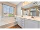 Bright bathroom with a soaking tub under a window and a dual sink vanity at 11901 Luna Del Mar Ln, Las Vegas, NV 89138