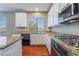 Gourmet kitchen features an island, stainless steel appliances, granite counters, and hardwood floors at 11901 Luna Del Mar Ln, Las Vegas, NV 89138