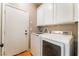 Functional laundry room with white cabinets and modern washer and dryer at 11901 Luna Del Mar Ln, Las Vegas, NV 89138