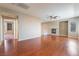 Spacious living room featuring a cozy fireplace, hardwood floors, and a ceiling fan at 11901 Luna Del Mar Ln, Las Vegas, NV 89138