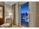 Balcony view showcasing city lights, tall buildings, and neutral curtains with a chair at 135 E Harmon Ave # 2821, Las Vegas, NV 89109