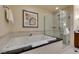 A luxurious bathroom features a soaking tub with black countertop and a glass enclosed shower at 135 E Harmon Ave # 2821, Las Vegas, NV 89109