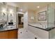 A spacious bathroom features a soaking tub, glass enclosed shower, black countertops, and tile flooring at 135 E Harmon Ave # 2821, Las Vegas, NV 89109