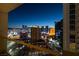 A night view shows a vibrant cityscape with multiple buildings, as seen from a balcony at 135 E Harmon Ave # 2821, Las Vegas, NV 89109