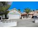 Inviting single-story home with a well-manicured lawn, complemented by a two-car garage and mature palm trees at 1950 Turtlerock St, Las Vegas, NV 89142