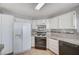 Traditional kitchen featuring white cabinets, tile countertops, and essential appliances at 1950 Turtlerock St, Las Vegas, NV 89142