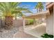 View of back patio with concrete base, rock landscaping, and lush green plants on a sunny day at 1981 Spring Lake Dr, Henderson, NV 89002