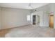 Bright, carpeted bedroom with ceiling fan, closet, and a door to another room at 1981 Spring Lake Dr, Henderson, NV 89002