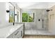 Bright bathroom featuring a walk-in shower with gray tiles and a double vanity with modern finishes and natural light at 2105 Madagascar Ln, Las Vegas, NV 89117