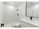Bright white bathroom featuring a tiled shower, modern fixtures, and a vanity with sink at 2105 Madagascar Ln, Las Vegas, NV 89117