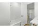 Bright, tiled bathtub with a white door that leads to a room with plush gray carpeting at 2105 Madagascar Ln, Las Vegas, NV 89117