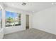 Bright bedroom featuring a neutral carpet, a large window and a clear view of the front yard at 2105 Madagascar Ln, Las Vegas, NV 89117
