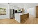 Modern kitchen features stainless appliances, island with countertop, and wood grain flooring at 2105 Madagascar Ln, Las Vegas, NV 89117